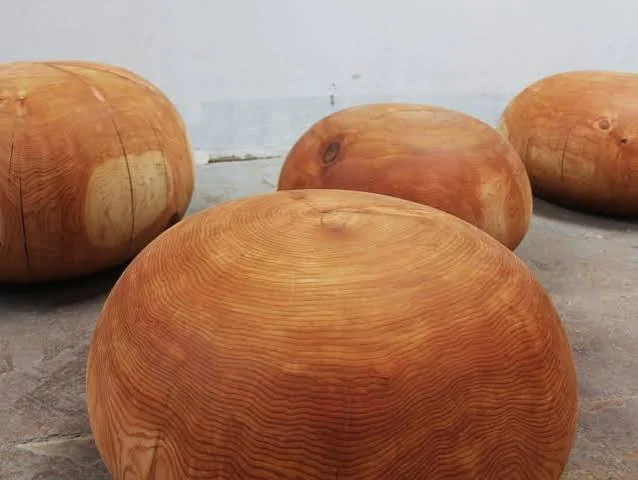 Hand-carved solid cedar pebble sculpture — growth rings and end grain. CIBC Flagship, Commerce Court, Toronto